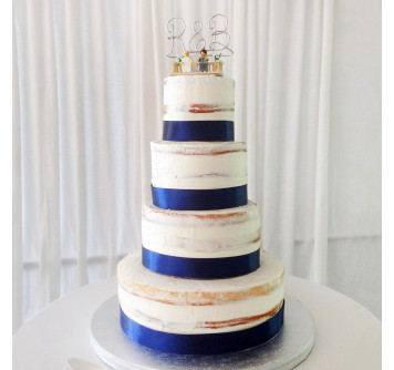 Свадебный торт с синей лентой и фигурками молодоженов